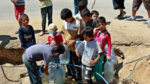 Syrian refugees boys fill up their water bottles, at a temporary refugee camp in the eastern Lebanese town of Faour near the border with Syria, Lebanon, Wednesday, Aug. 28, 2013. U.N. chemical weapons experts headed to a Damascus suburb on Wednesday for a new tour of areas struck by a purported poison gas attack, activists said, as the U.S. laid the groundwork for a possible punitive strike and the U.N. chief pleaded for more time for diplomacy. (AP Photo/Bilal Hussein)